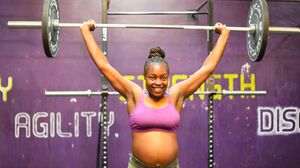 Jane Kabogo performs an overhead barbell press at the Kaizen gym.